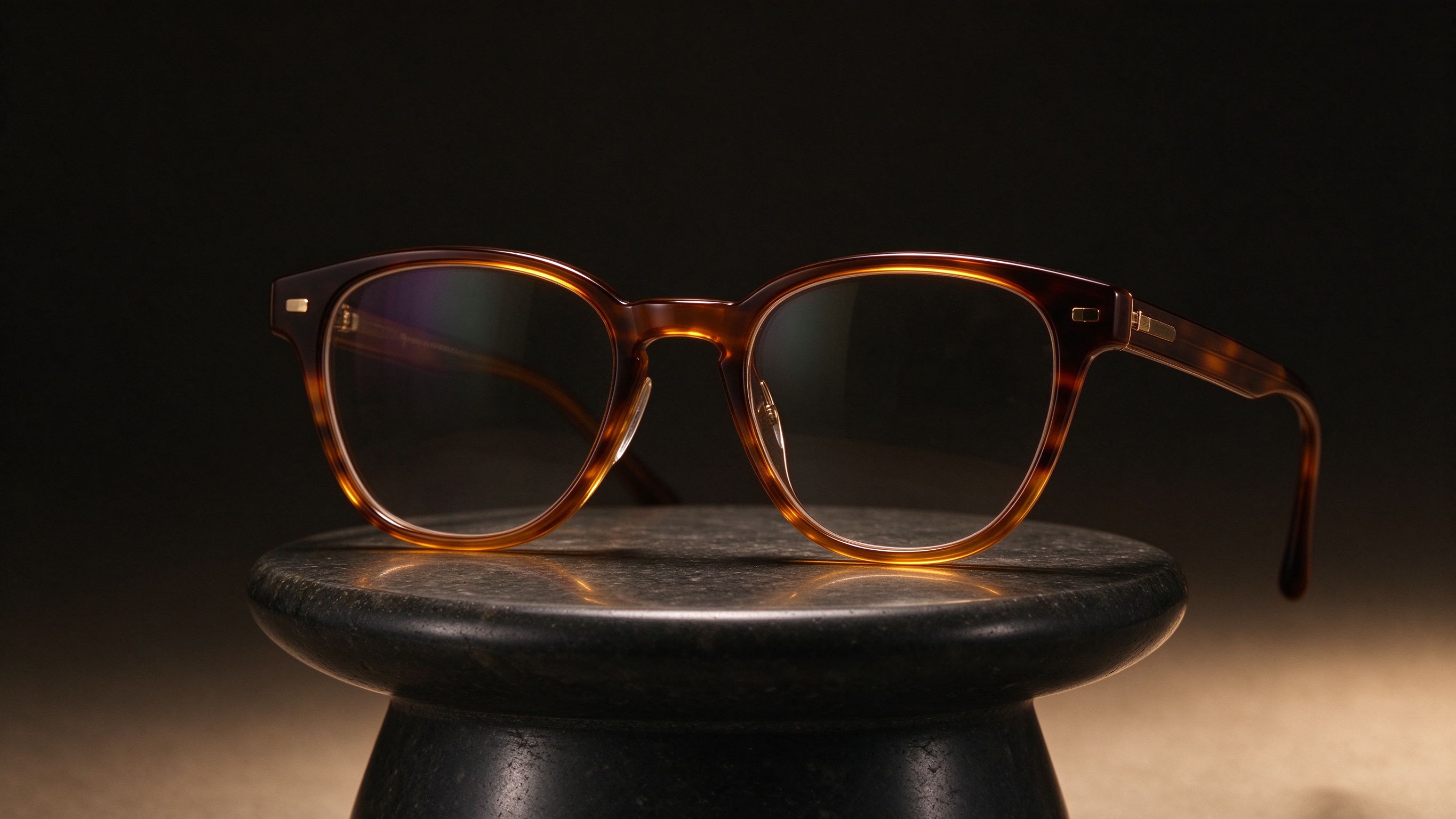 Handcrafted tortoiseshell acetate eyeglasses on a dark stone pedestal