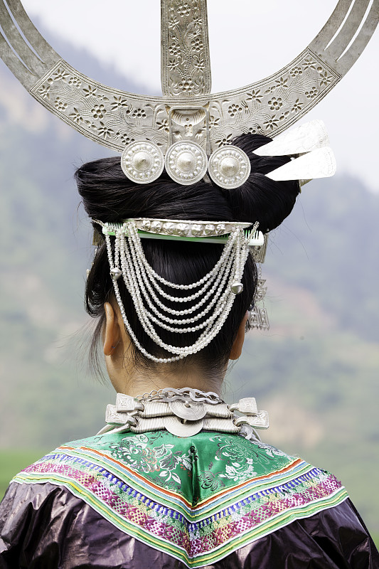 Miao silver headdress and embroidered collar in close-up